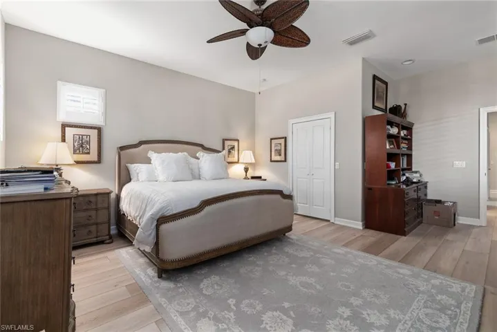 Bedroom featuring light wood-type flooring, a closet, and a ceiling fan