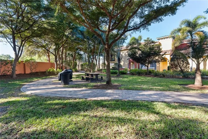 View of parklike setting with picnic table and gas grill right outside front door