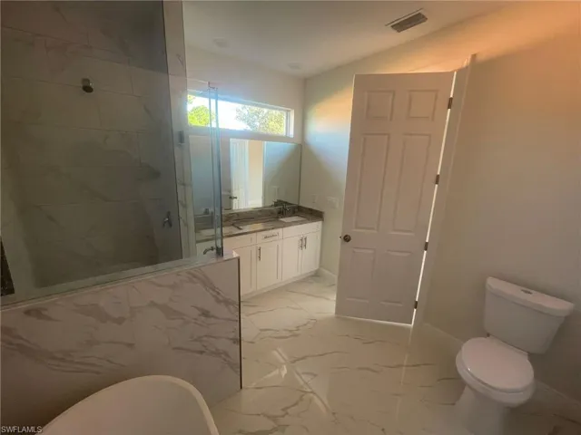 Unfurnished living room featuring light tile patterned flooring, ceiling fan, sink, and a tray ceiling