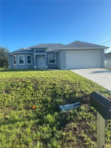 View of front of house with a garage and a front lawn
