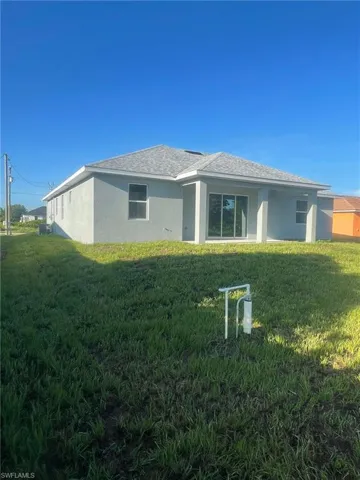 Back of property featuring a lawn