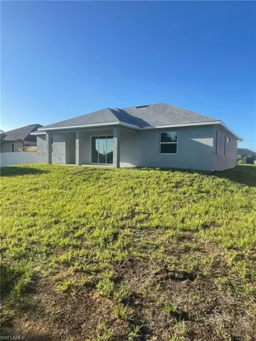 Back of house featuring a yard