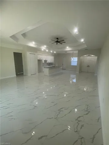 Tiled spare room featuring ceiling fan
