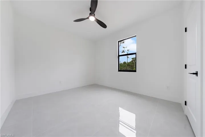 Spare room with a ceiling fan, baseboards, and light tile patterned flooring