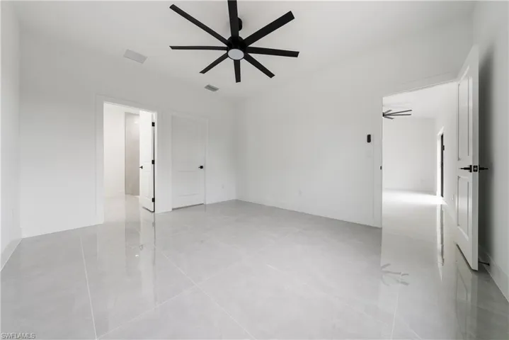 Unfurnished room with a ceiling fan and baseboards