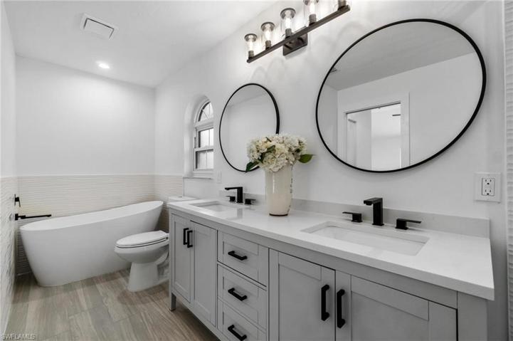 Primary bathroom featuring new tub and commode