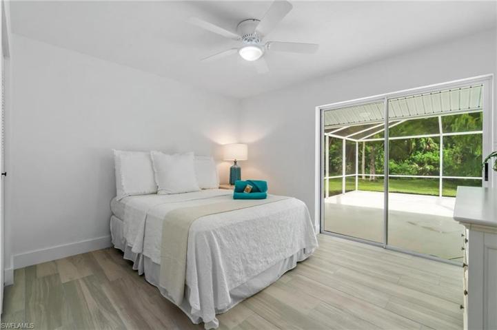 secondary guest bedroom featuring a queen-size bed and sliders out to lanai