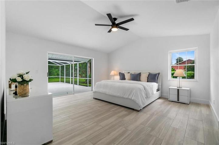 Primary Bedroom with sliding glass doors leading to the newly resurfaced, painted and screened in lanai