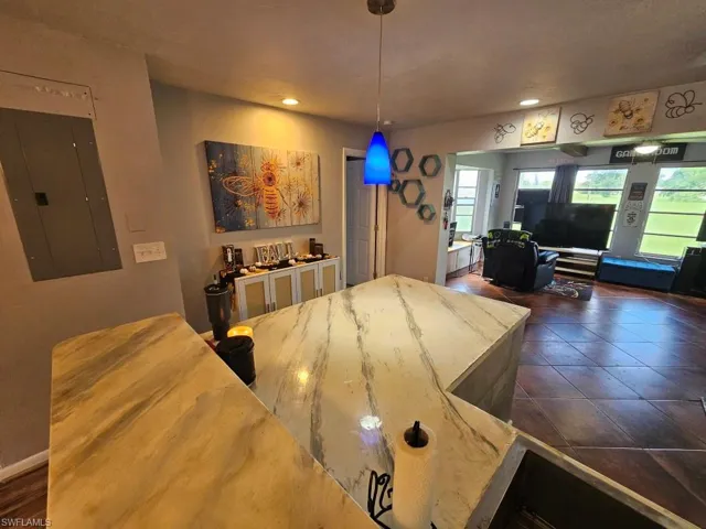 Dining area with electric panel, dark tile patterned floors, and recessed lighting