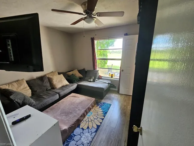 Living area featuring wood finished floors, ceiling fan, and a textured ceiling