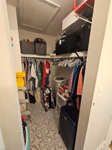 Spacious closet featuring attic access and light tile patterned floors