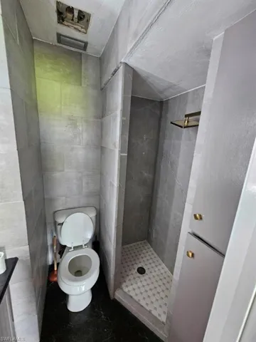 Full bath with tile walls and a shower stall