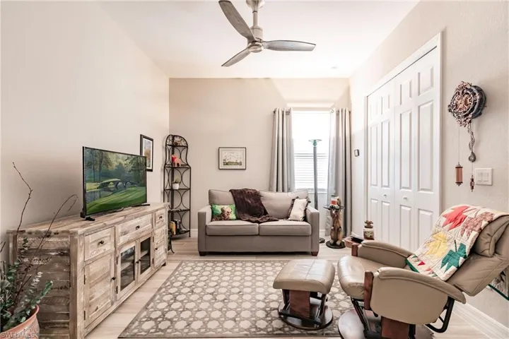Den featuring file flooring and ceiling fan. This could be used as a 4th bedroom, with a closet.