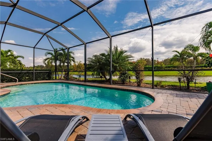 View of pool featuring a water view, a patio, and a lanai