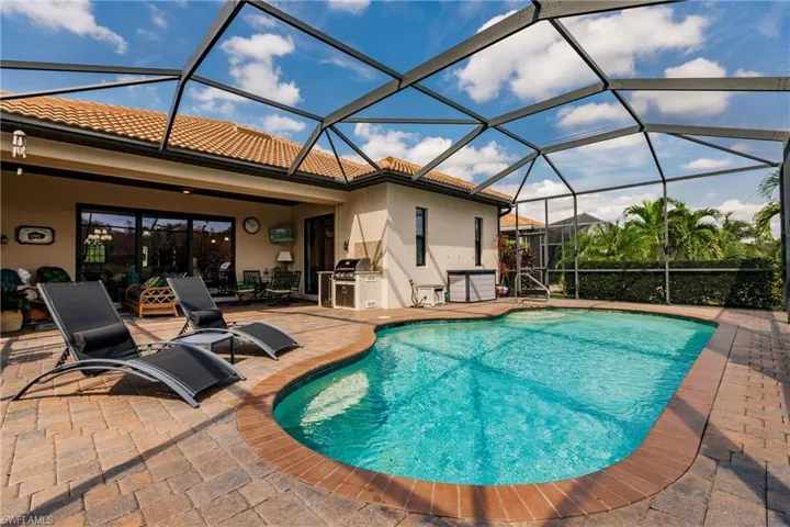 View of pool with a patio and screened enclosure