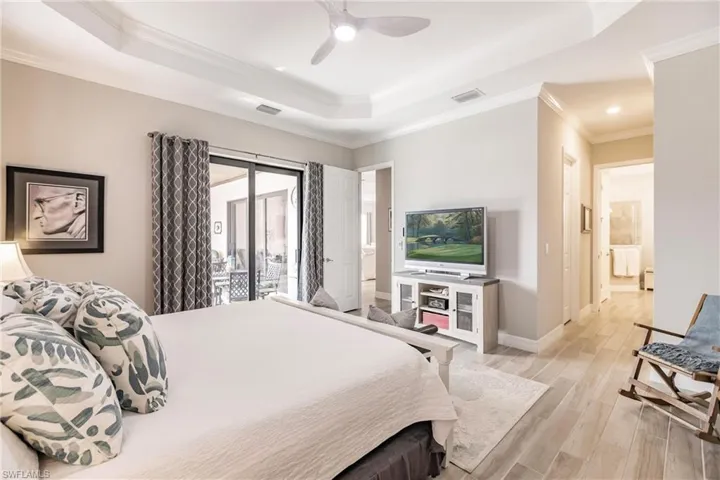Bedroom featuring ceiling fan, access to outside, ornamental molding, and ensuite bathroom