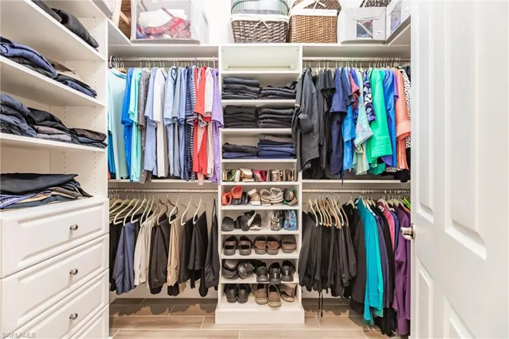 Walk in closet featuring built in organization.