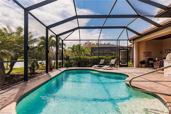 View of pool featuring a patio and screened enclosure