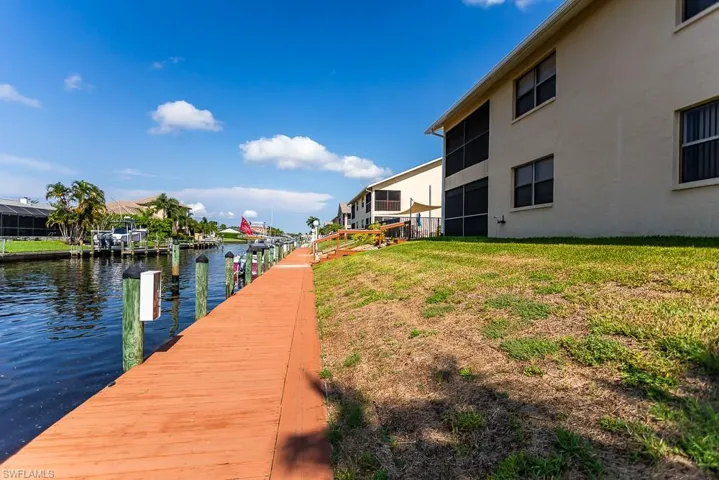 View of dock with a water view and a yard