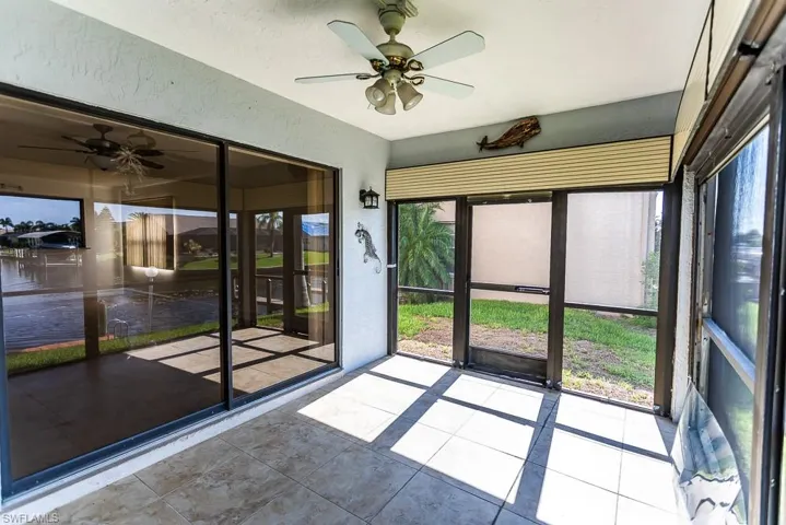 Unfurnished sunroom with plenty of natural light and ceiling fan