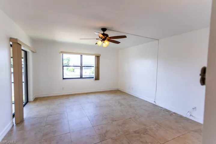 Spare room with ceiling fan and light tile patterned floors