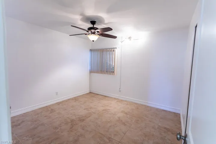 Spare room featuring ceiling fan and light tile patterned floors