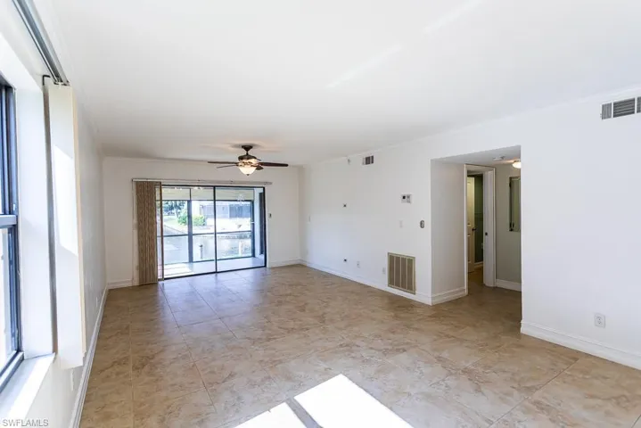 Unfurnished room featuring ceiling fan, light tile patterned floors, and ornamental molding