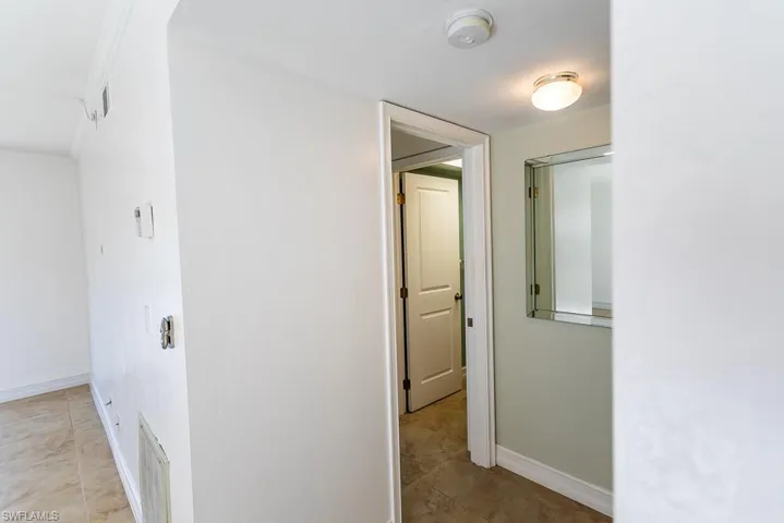 Hall featuring crown molding and light tile patterned flooring