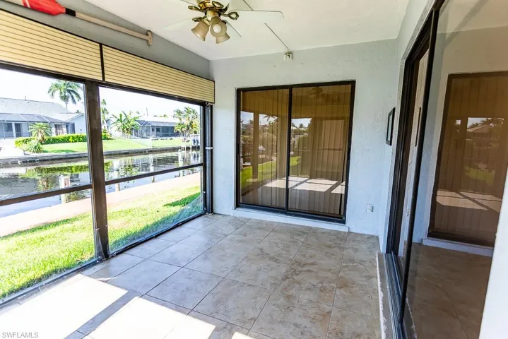 Unfurnished sunroom with a wealth of natural light and ceiling fan