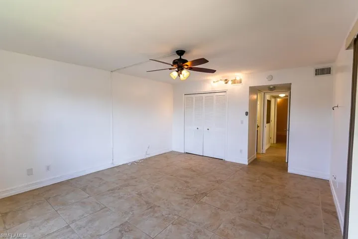 Unfurnished bedroom with a closet, ceiling fan, and light tile patterned flooring