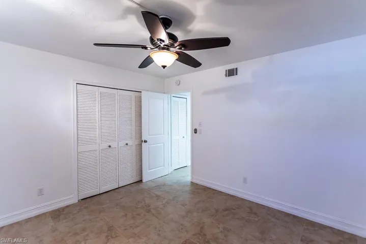 Unfurnished bedroom with ceiling fan, a closet, and light tile patterned floors