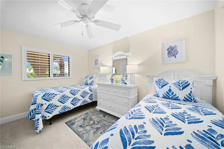 Recessed ceiling with a white ceiling fan, white window shutters, and light-toned wall paint