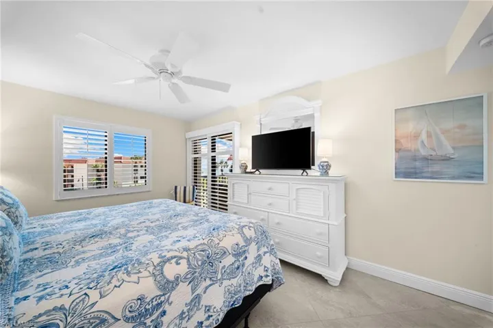 Recessed ceiling lighting, ceiling fan, white window shutters, and tile flooring