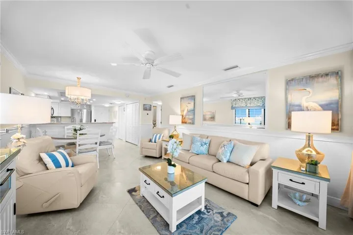 Open-concept living area with tile flooring and crown molding