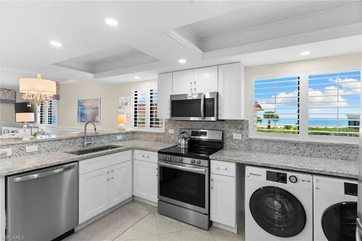 Kitchen with white cabinetry, stainless steel appliances, granite countertops, and recessed lighting