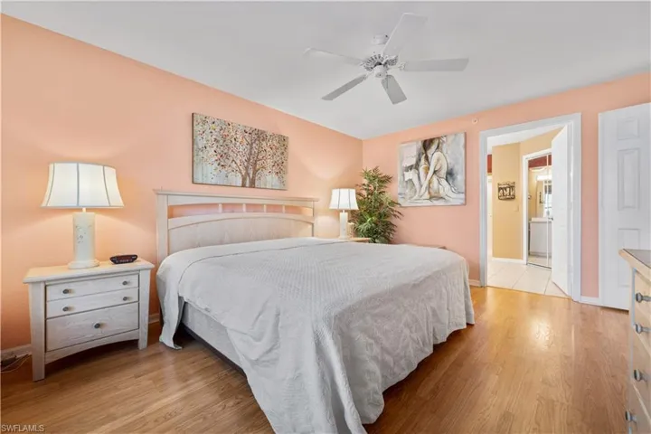Bedroom featuring light hardwood / wood-style floors, ensuite bathroom, and ceiling fan