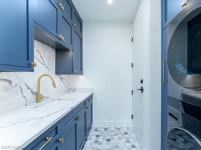 Laundry room with stacked washer / dryer and cabinet space