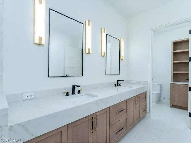 Bathroom with double vanity and toilet