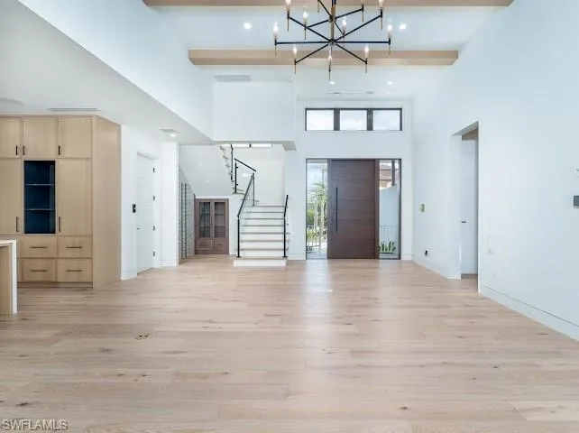 Entrance foyer with light wood-style floors and a chandelier