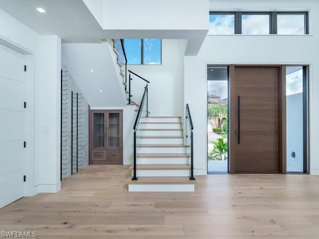 Foyer featuring light wood finished floors and a high ceiling