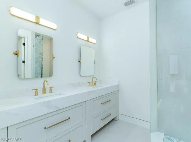 Bathroom featuring walk in shower and double vanity
