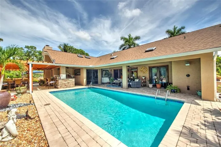 View of swimming pool featuring a patio and an outdoor kitchen