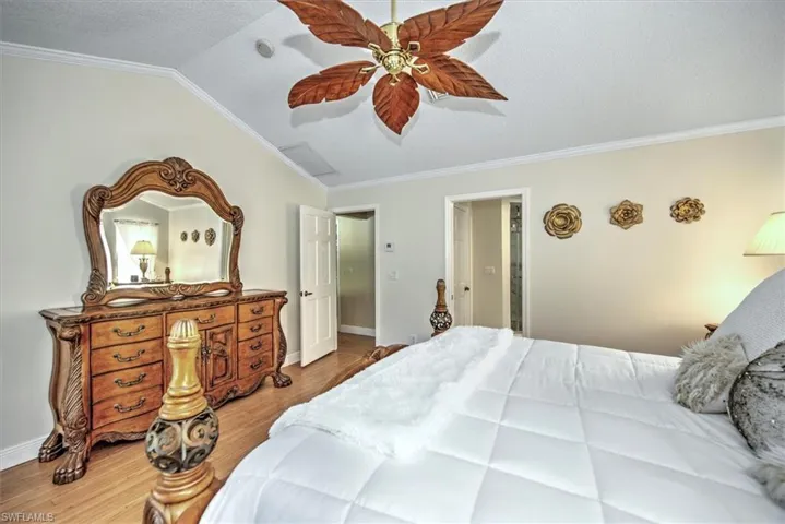 Bedroom with ceiling fan, hardwood / wood-style flooring, and ornamental molding
