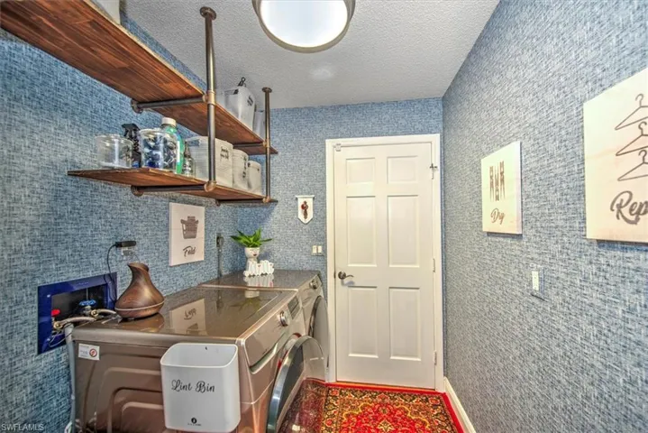 Kitchen featuring washing machine and dryer and a textured ceiling