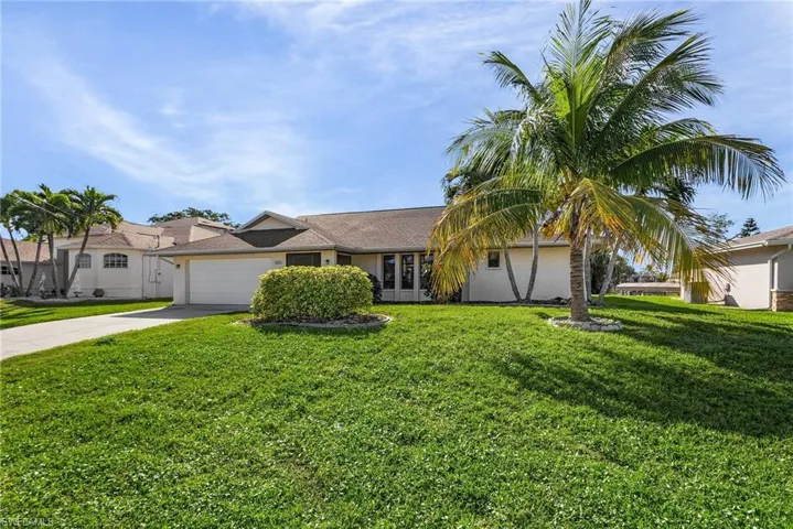 View of front of house with a front yard, french doors, and a garage