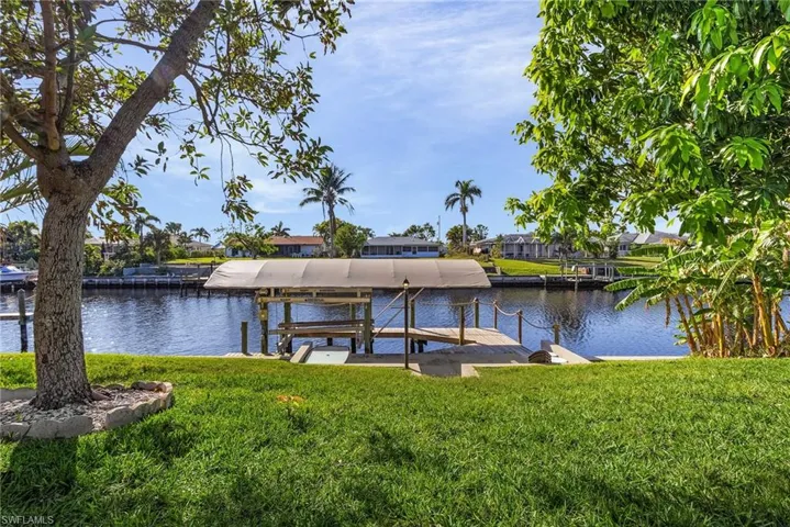 View of dock with a water view and a yard