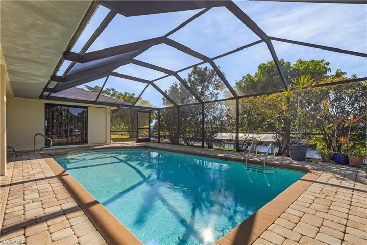 View of swimming pool featuring a patio and a lanai