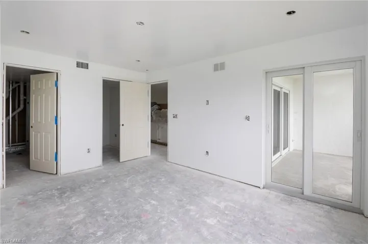 Primary Bedroom with ensuite bath and impact slider leading onto the lanai