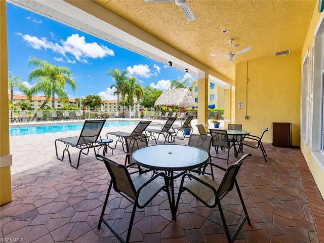Expansive covered patio featuring a textured yellow ceiling with multiple ceiling fans
