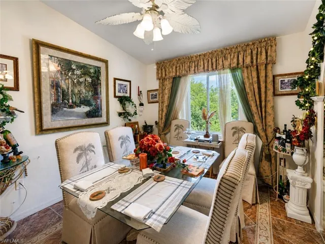 Dining area featuring a glass-top table, decorative window treatments, and patterned floor tiling